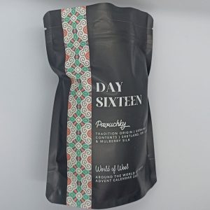 Schwarzes Tütchen mit der Aufschrift "Day Sixteen", "Pavuchky" und der Beschreibung zu der enthaltenen Faser.